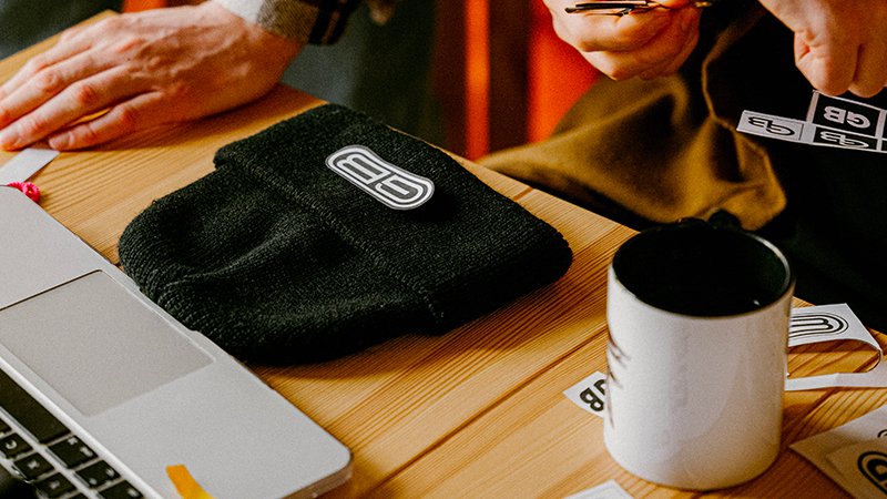 laptop, hat and mug on table