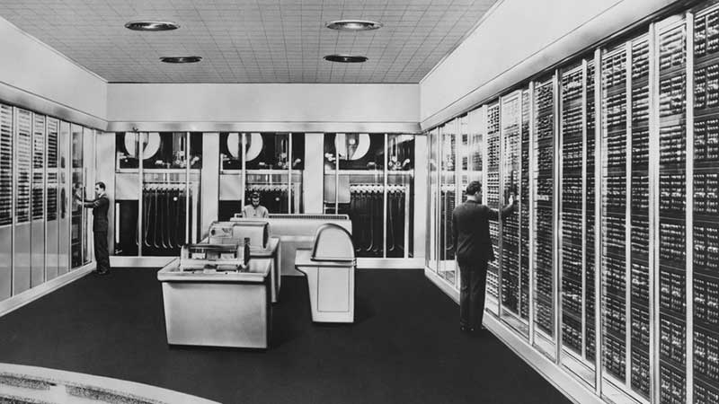 Historical photo of employees working in a computer room in the 1950s. Historical photo of employees working in a computer room in the 1950s.