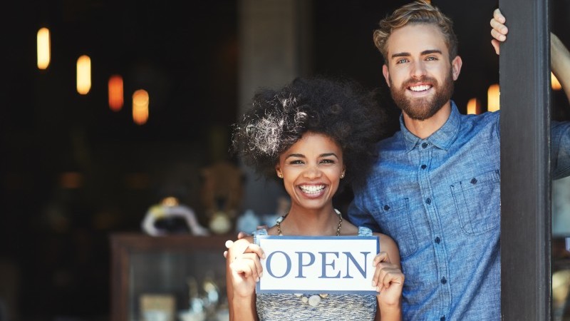 couple holding open sign